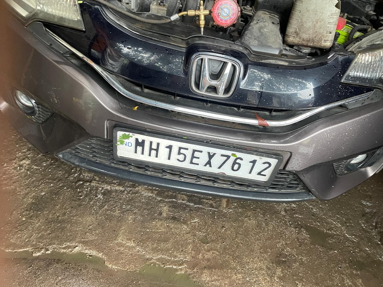 Honda Jazz with bonnet open for AC and engine servicing