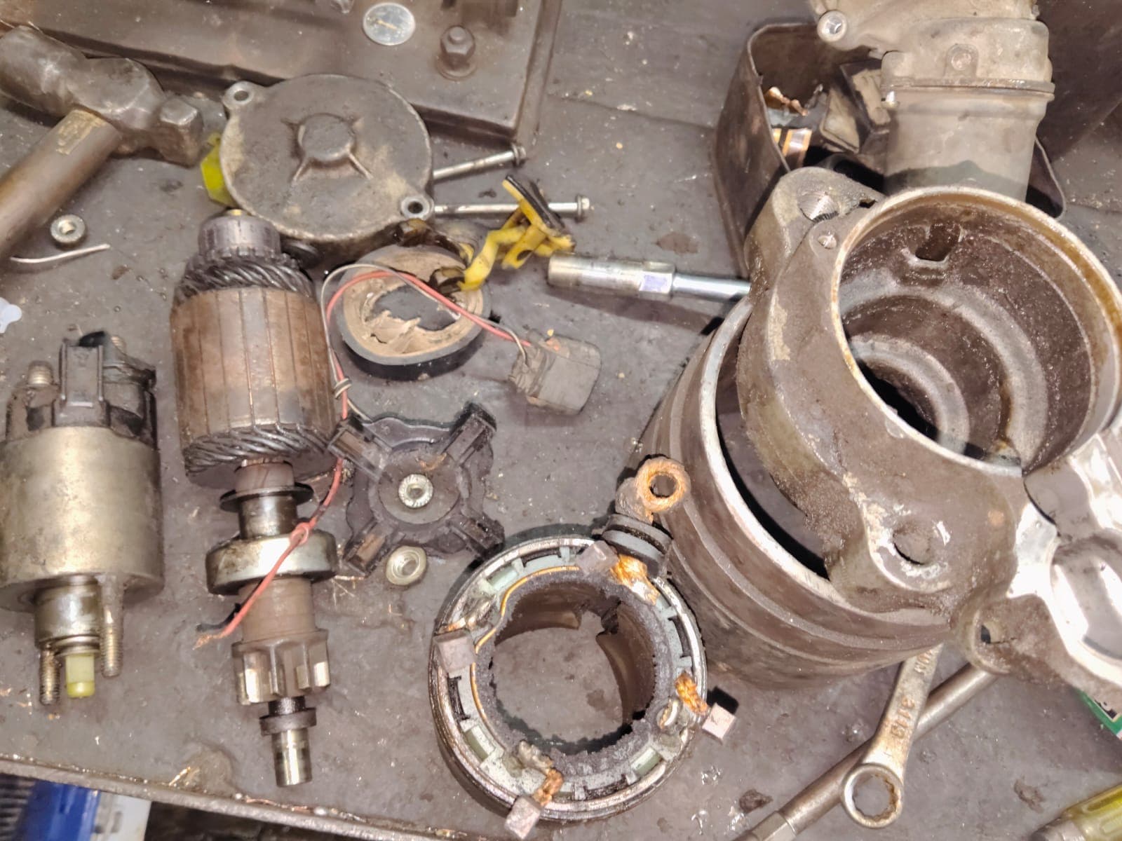 Disassembled starter motor and alternator parts laid out for repair